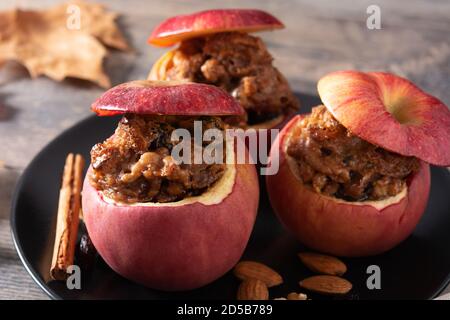Stuffed apples baked with nuts on wooden table Stock Photo