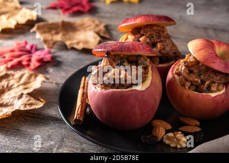 Stuffed apples baked with nuts on wooden table Stock Photo