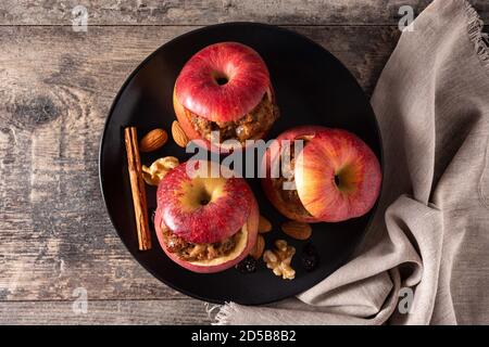 Stuffed apples baked with nuts on wooden table Stock Photo