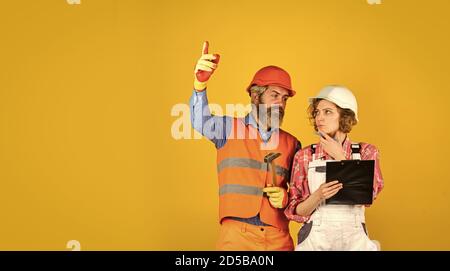 job and occupation. confident electrical and technician. engineers couple working together on building blueprint. work at construction site or factory. Civil engineering. industrial business partner Stock Photo