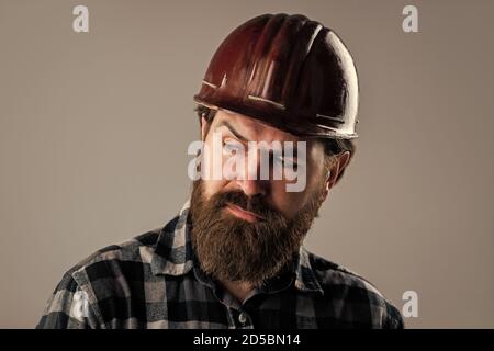 serious male worker wear hard hat. brutal builder in helmet. bearded repairman. confident construction engineer. professional architect. repair and building. responsible for safety. Stock Photo