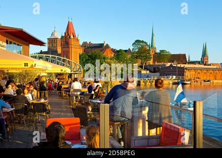 Deutschland, Schleswig-Holstein, Hansestadt Lübeck, Restaurant am Untertrave mit Blick auf das Schlosstor und die Marienkirche. Stock Photo