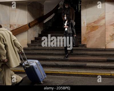 Moscow. Russia. October 5, 2020 People passengers with protective masks on their faces inside the metro station descend the stairs. Preventive Stock Photo