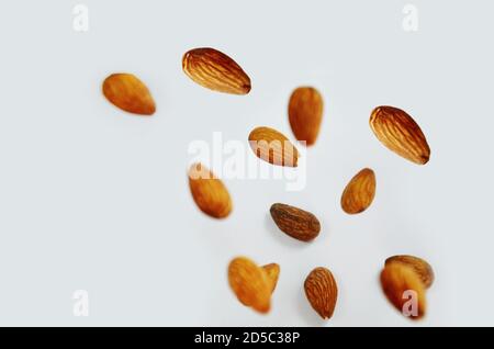 almonds fly on a white background. Composition of nuts flat lay almonds on white background. Concepts about decoration, healthy eating and food Stock Photo