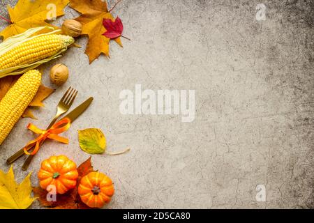 Thanksgiving table setting with cutlery pumpkins and autumn leaves Stock Photo