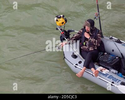Man fishing with rod from inflatable rubber boat on river Stock Photo -  Alamy