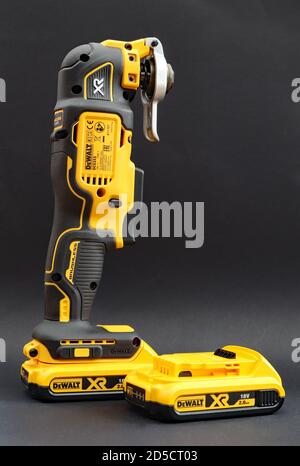 OTTERY ST MARY, DEVON - FEBRUARY 6TH 2020: Dewalt Cordless Multi Tool stands upright on its battery on a black background. A spare battery is by the s Stock Photo