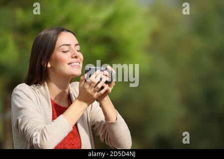 Happy woman breathing fresh air standing alone in a park Stock Photo ...