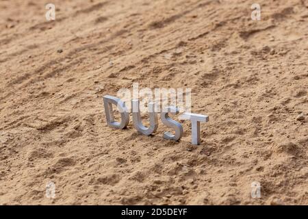 the word dust standing on dusty road surface in linear perspective Stock Photo