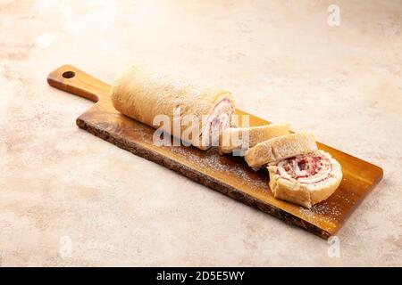 Baked biscuit swiss roll dessert with fruits and cream chopped on pieces Stock Photo