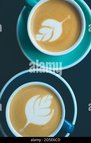 Cappuccino coffee in flat lay.Two cups of latte macchiato on table in Italian cafe.Aromatic decaffeinated drinks served for lunch in restaurant.Enjoy Stock Photo