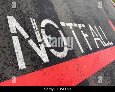View on isolated german word Notfall (english meaning: emergency) with red line paint on asphalt at entrance of emergency room Stock Photo