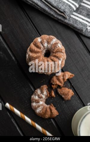 Sweet rings cookies. Biscuits with cocoa flavor on black table. Top view. Stock Photo