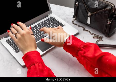 Womans hands with trendy red manicure typing on the keyboard Stock Photo