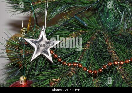 Christmas tree garland and decorations with a silver star on left for holiday themes. Stock Photo