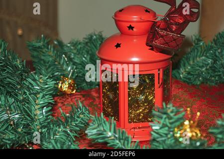 Christmas wreath on red table cloth and lantern candle holder for holiday concepts and themes. Stock Photo
