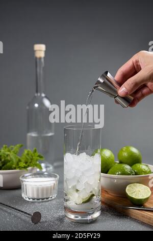 Man's hand pouring a glass of citrus juice into a beverage dispenser.  Operate the valve to close and open the tap of the juice bottle Stock Photo  - Alamy