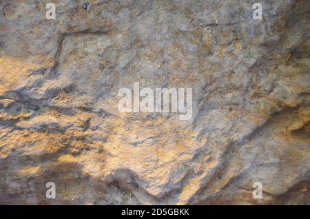 Details of sand stone texture, closeup shot of rock surface with vignette at cover and bright spot at centre, idea for background or backdrop. Stock Photo