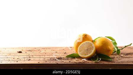 Harvest lemons on wooden table with white isolated background. Front view. Horizontal panoramic composition. Stock Photo