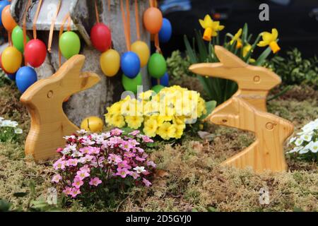 Selective focus shot of wooden easter  bunnies and eggs decorated in a garden Stock Photo