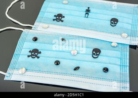 Protective surgical masks with skulls and rhinestones. Hallowing concept. Isolated on black background. Flat lay Stock Photo