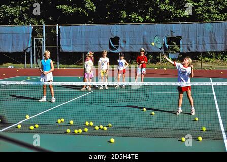 Children participate and learn the game of tennis having lessons in a clinic Stock Photo