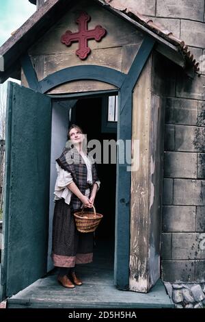 A woman parishioner at the door of an old Church in wild West America Stock Photo