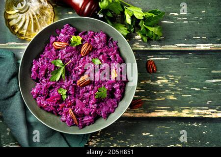 Top view of a plate with red cabbiage salad on green wooden background Stock Photo
