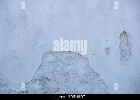 Old distressed stone white wall, building facade texture background, Whitewashed aged cracked wall, retro weathered plaster material. Stock Photo