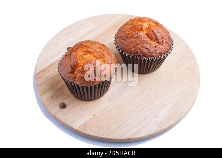 two carrot muffins  on wooden kitchen board isolated on white background. closeup. Stock Photo