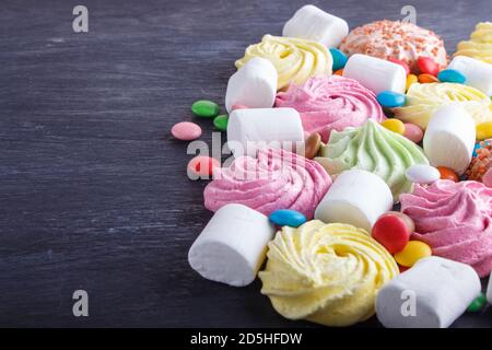 mixed multicolored candies on black wooden background. copy space, top view, flat lay. Stock Photo