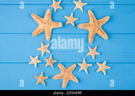 Top above overhead view close-up photo of a pattern of starfish isolated on blue wooden background with copyspace Stock Photo