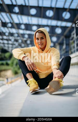 Fitness female taking break outdoors after hard workout Stock Photo