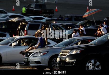(201013) -- LOS ANGELES, Oct. 13, 2020 (Xinhua) -- People watch the live of a baseball match between the Los Angeles Dodgers and Atlanta Braves at a parking lot of the Dodgers' stadium in Los Angeles, California, the United States, on Oct. 12, 2020. Dodgers fans drove into parking lots at the team's stadium Monday to watch the game against the Atlanta Braves. Vehicles were required to park in every other spot, following the physical distancing requirements laid out by public health officials. Fans had their temperatures checked before entering the venue to park and watch the game on big screen Stock Photo