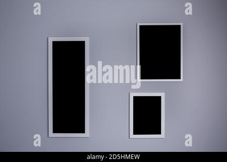 Poster mockup with three frames on empty grey wall  Stock Photo