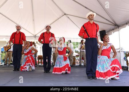 Couples dressed in traditional costumes pose after the dance on the stage in the center.San Juan, Puerto Rico. Stock Photo