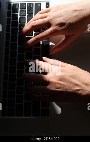 Woman's hands typing on laptop Stock Photo