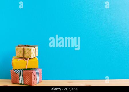 Colorful gift boxes on wooden table with blue background Stock Photo