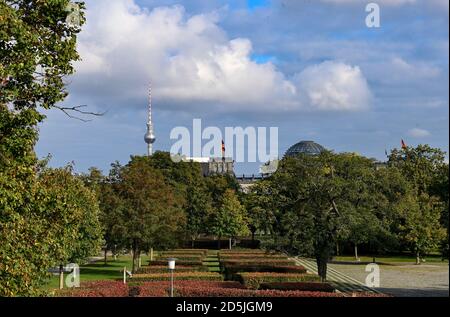 Berlin, Germany. 12th Oct, 2020. Concealed behind trees, the Reichstag building is visible with German flags. On the left the television tower. Credit: Jens Kalaene/dpa-Zentralbild/ZB/dpa/Alamy Live News Stock Photo