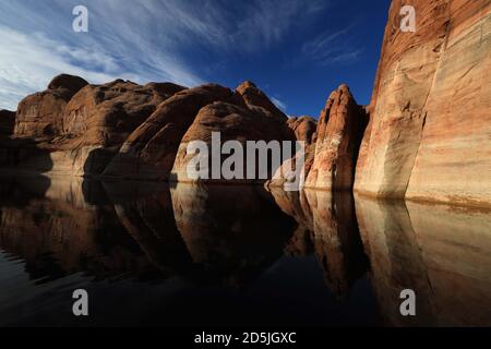 Lake Powell, Arizona, USA. 13th Aug, 2020. Sunrise on red rock canyons near Rainbow Bridge National Monument. Lake Powell is a man-made reservoir on the Colorado River in Glen Canyon National Recreation Area and straddles 2 western states Utah and Arizona. It is a major vacation spot, stretching from the beginning of the Grand Canyon in Arizona to southern Utah, Glen Canyon National Recreation Area is graced with scenic views, unique geology and 10,000 years of human history. Activities include boating, fishing, hiking. Lake Powell, is the second largest man made lake in the United States, an Stock Photo