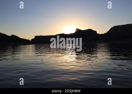 Lake Powell, Arizona, USA. 13th Aug, 2020. Sunset on the waters. Lake Powell is a man-made reservoir on the Colorado River in Glen Canyon National Recreation Area and straddles 2 western states Utah and Arizona. It is a major vacation spot, stretching from the beginning of the Grand Canyon in Arizona to southern Utah, Glen Canyon National Recreation Area is graced with scenic views, unique geology and 10,000 years of human history. Activities include boating, fishing, hiking. Lake Powell, is the second largest man made lake in the United States, and is a premier boating destination. Risks of Stock Photo