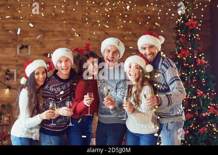 Happy friends with glasses of champagne celebrating Christmas. Stock Photo