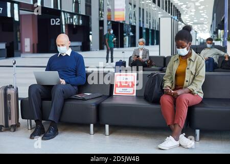 People sitting in waiting room and using gadgets at the airport Stock Photo