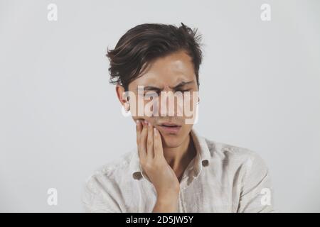 Closeup of a young man suffering from toothache isolated on white background Stock Photo