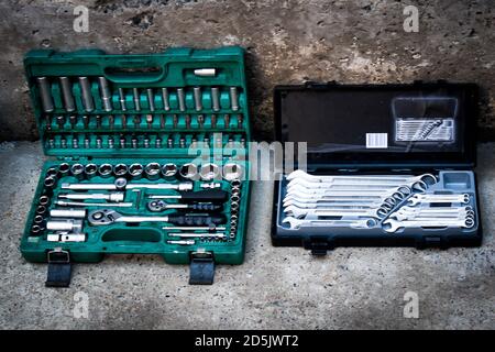 Professional mechanic tool kit in a box for repairing motorcycles and equipment. Closeup chrome steel tool on concrete in a garage. Collection of diff Stock Photo