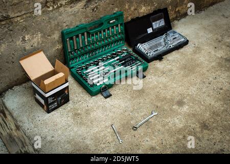Professional mechanic tool kit in a box for repairing motorcycles and equipment. Closeup chrome steel tool on concrete in a garage. Collection of diff Stock Photo