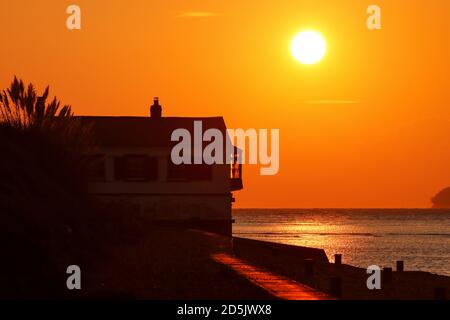 New Forest, Hampshire. 14th October 2020. UK Weather. Sunrise behind the old Coastguard Watch House on Lepe Beach in the New Forest. Credit Stuart Martin/Alamy Live News Stock Photo