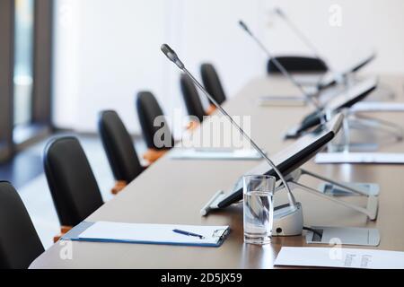 Image of empty table with documents and microphones at board room Stock Photo