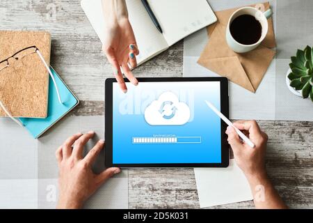 Cloud synchronization progress bar on tablet screen. Data storage and protection. Technology and internet concept Stock Photo