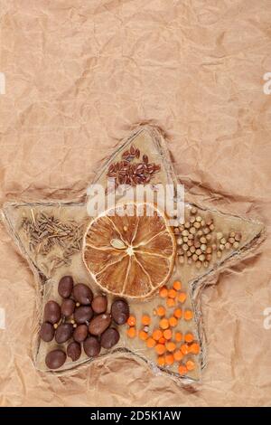 Dried lemon, coffee beans, cereals in a rope star. Christmas theme. Stock Photo